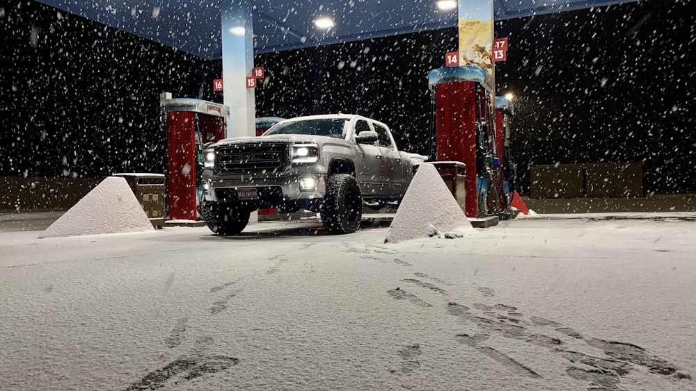 black suv on snow covered road during night time