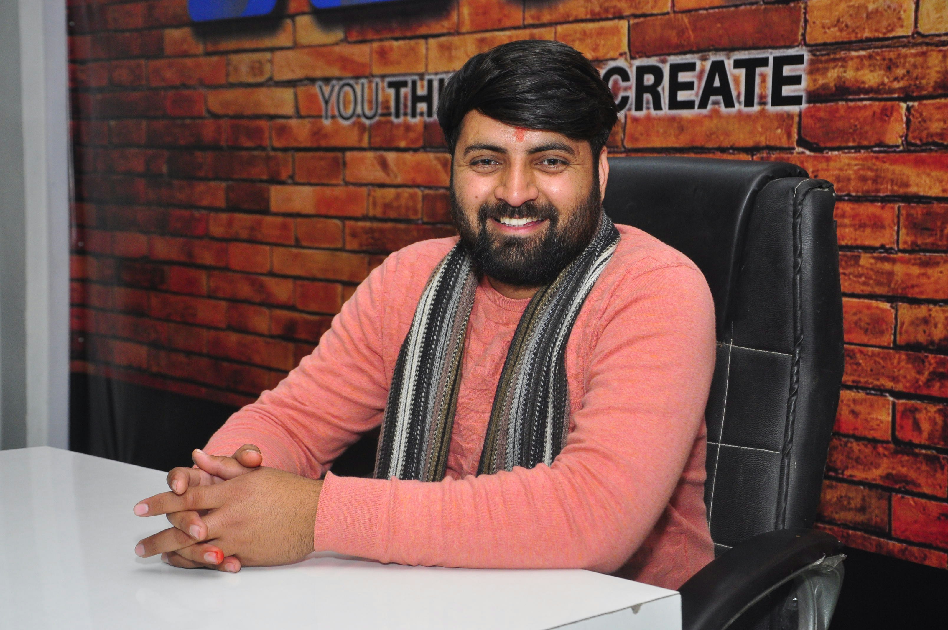 Man in red and white long sleeve shirt sitting on black leather chair