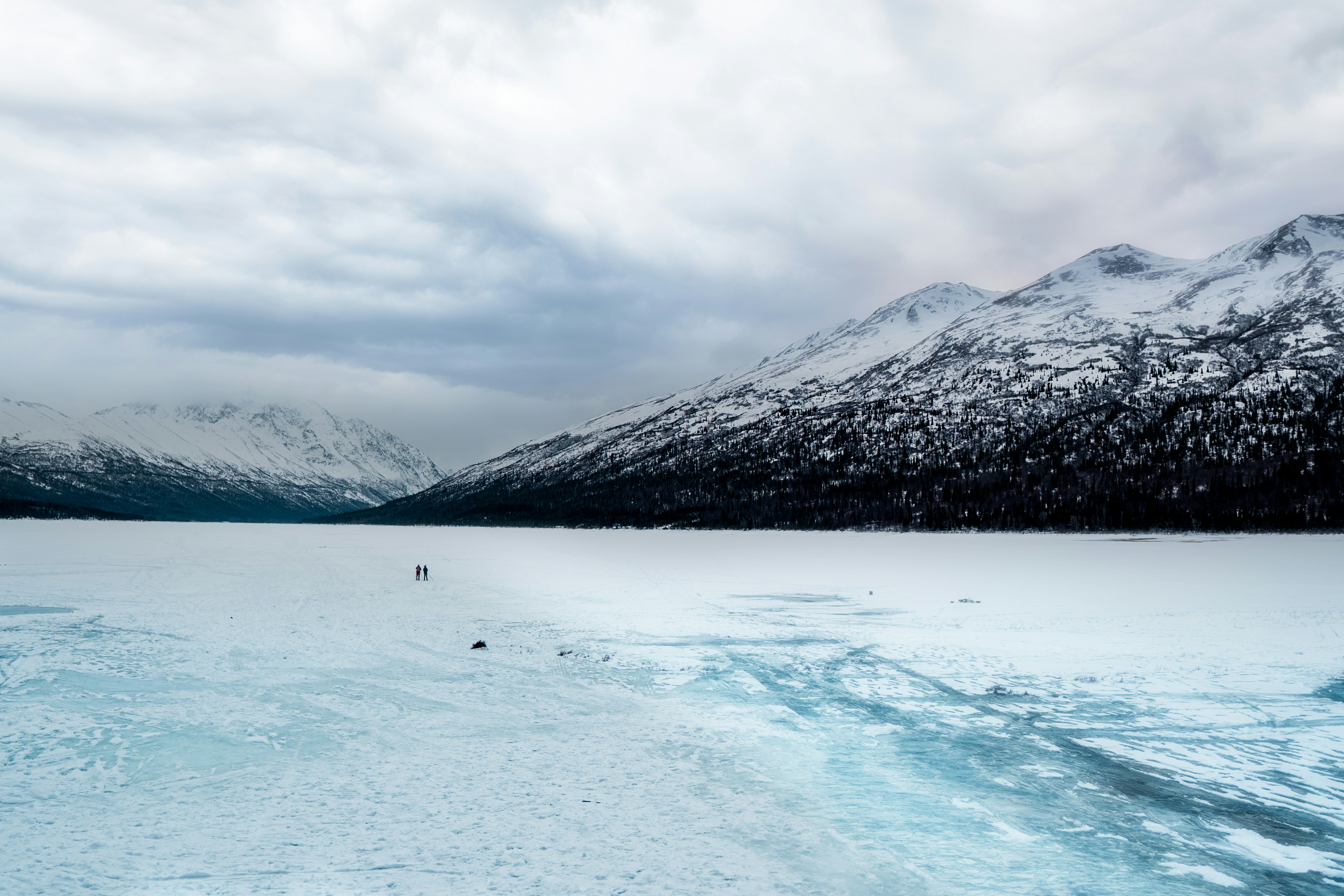 body of water near snow-covered mountain during daytime