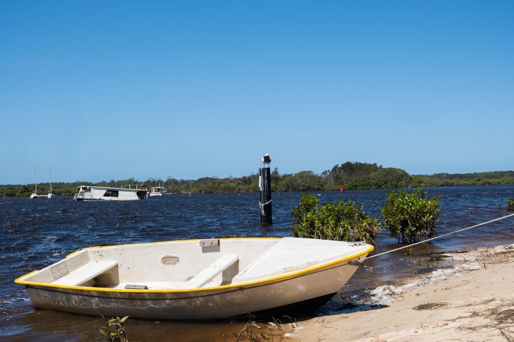 person standing on white and yellow boat on beach during daytime