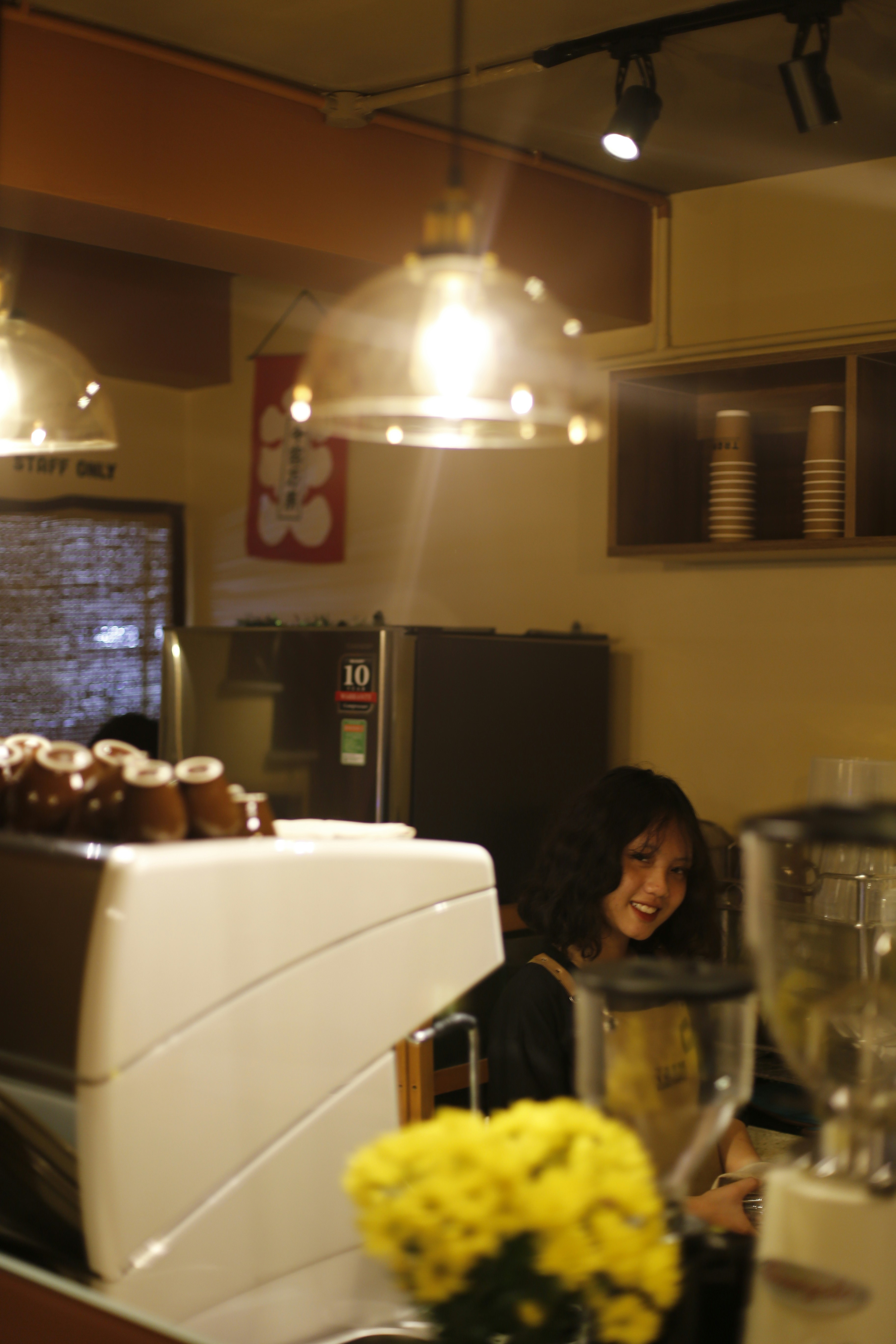 African woman barista at coffee house, warm smile