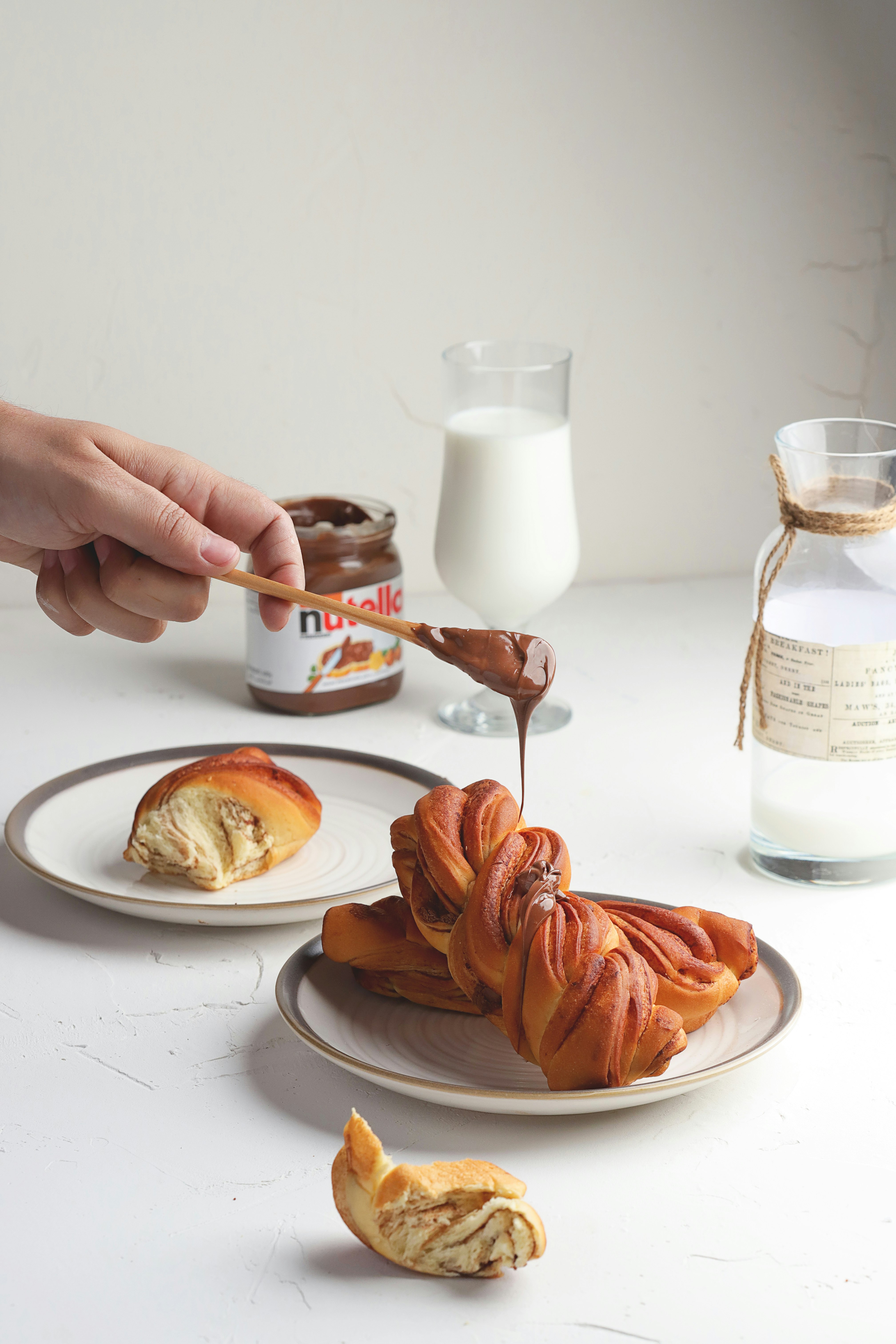 person pouring milk on white ceramic mug