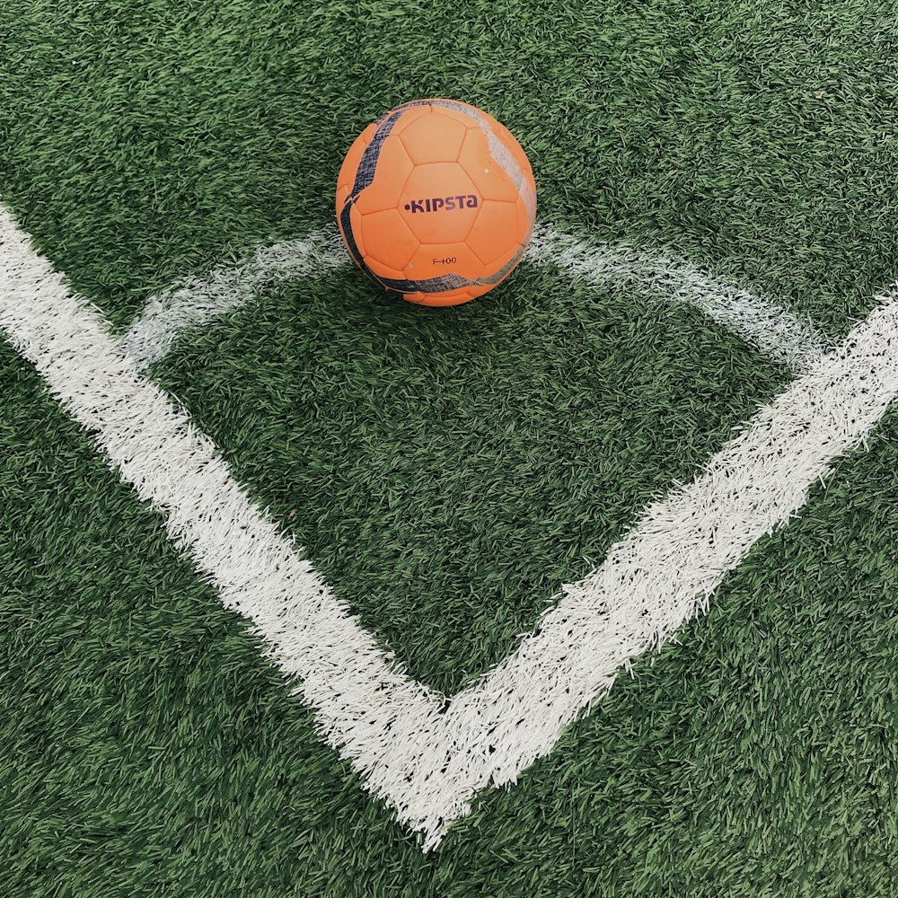 orange soccer ball on green grass field