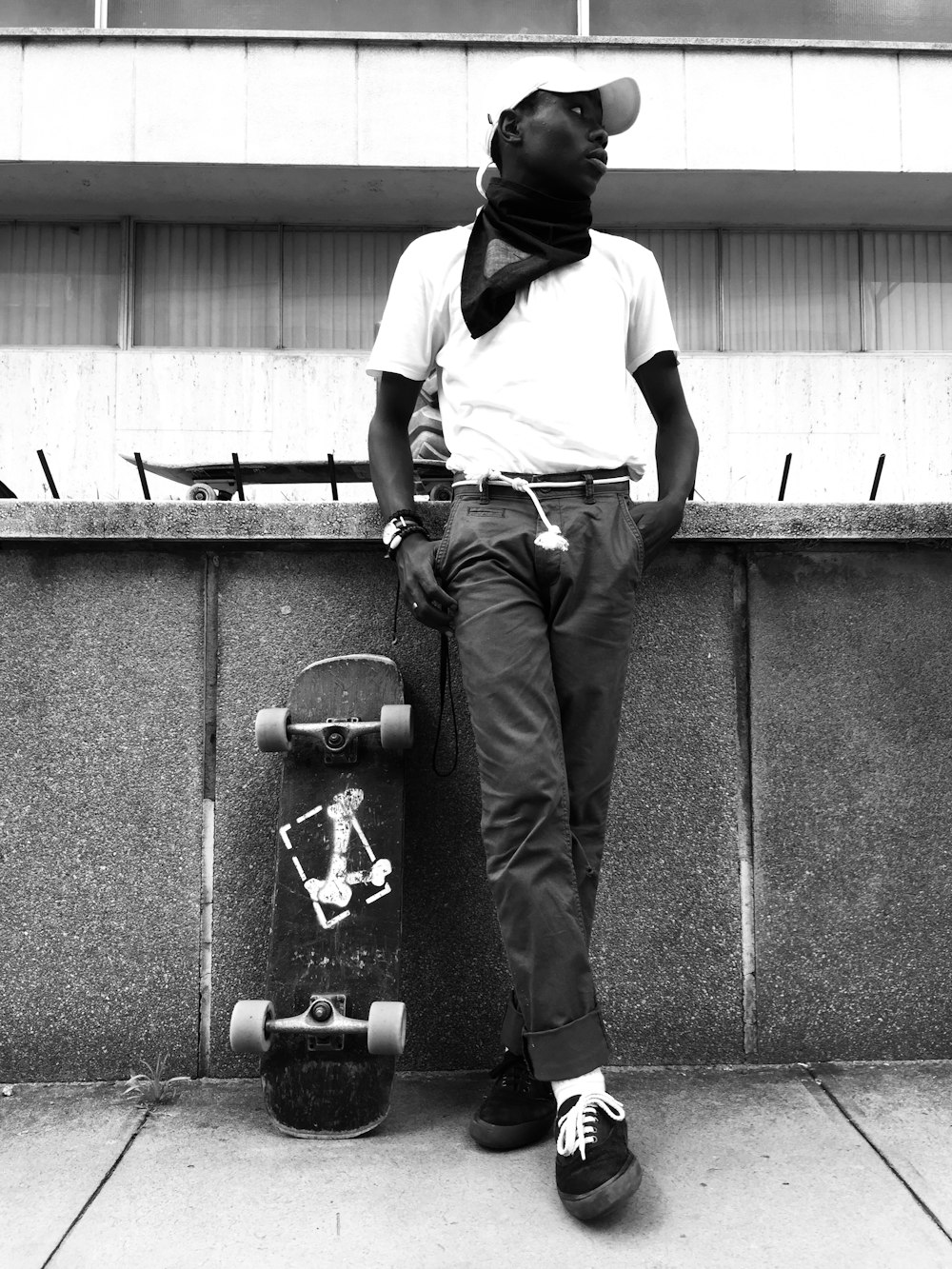 man in white dress shirt and black pants standing on black skateboard
