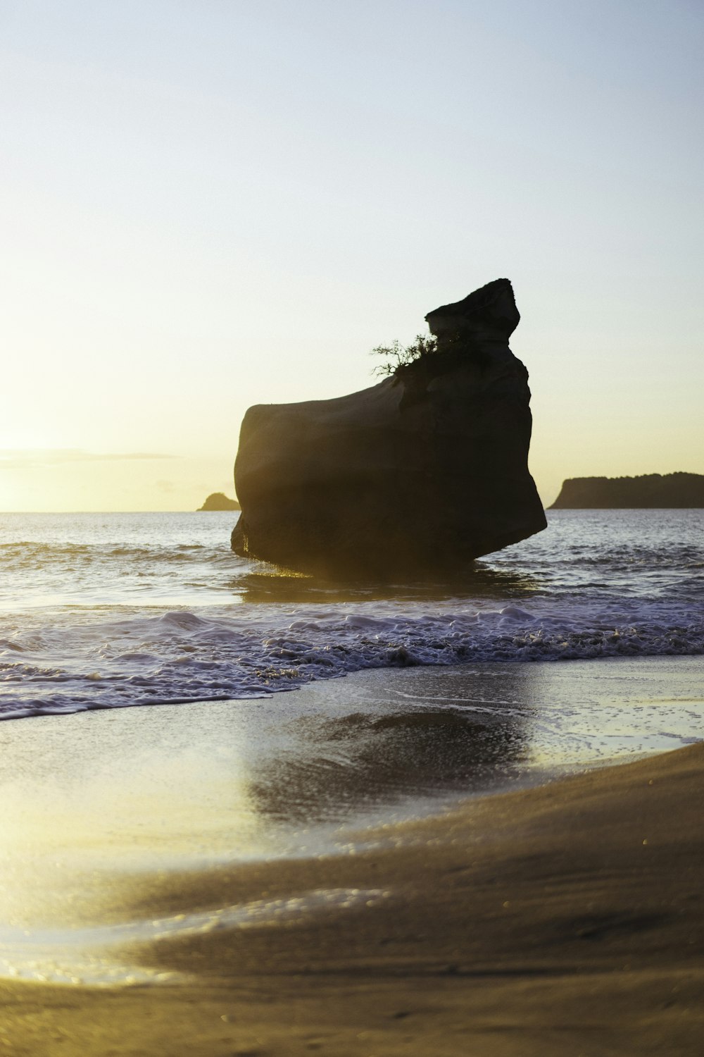 silhouette of rock formation on sea during daytime