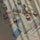A collection of printed photographs scattered on a textured fabric surface, with rolls of washi tape interspersed among them. The photos show various scenes, mostly nature-related, and are softly lit with shadow patterns cast across them, adding a serene and nostalgic feel.