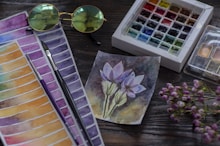purple flower painting on brown wooden table