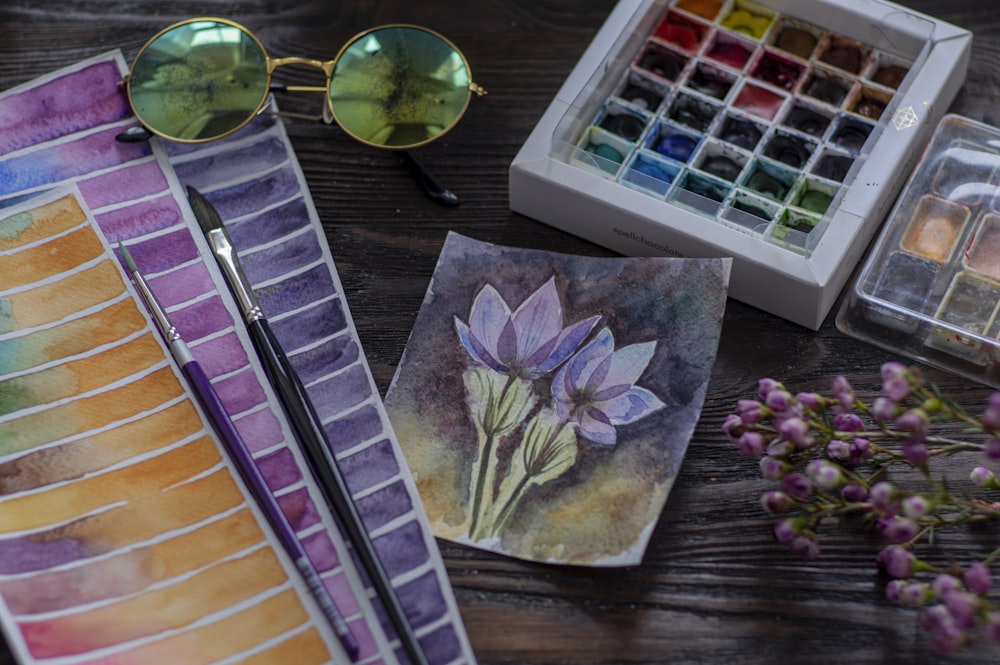 purple flower painting on brown wooden table