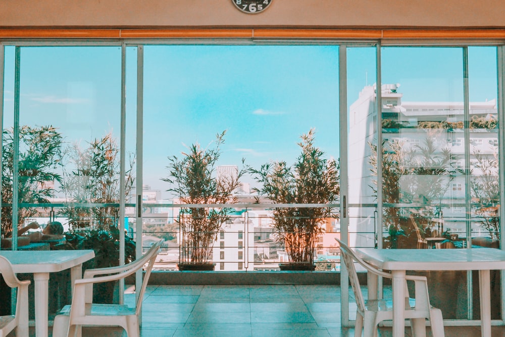 white wooden table and chairs near glass window