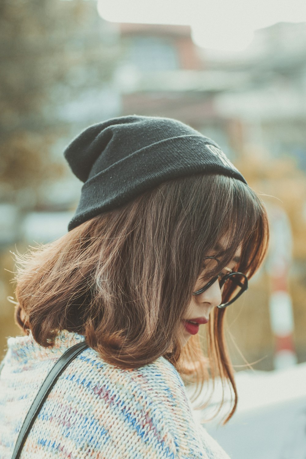 woman in black knit cap and blue and white floral shirt