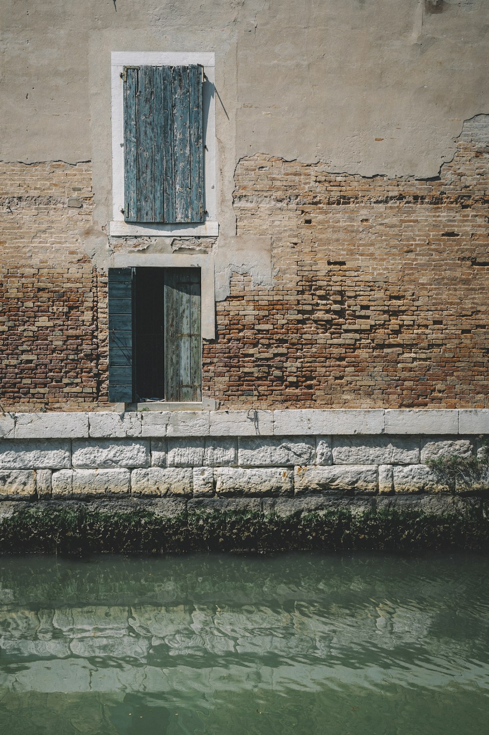brown brick wall beside body of water during daytime