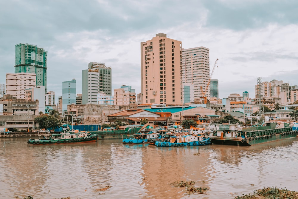 barco azul e branco na água perto de edifícios da cidade durante o dia