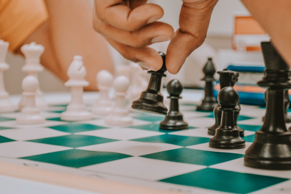 person holding black and white chess piece