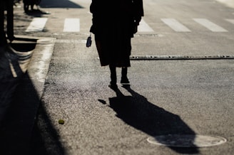 woman in black coat walking on the street during daytime