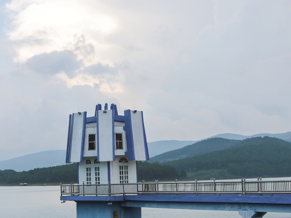 edificio in cemento bianco vicino a uno specchio d'acqua durante il giorno