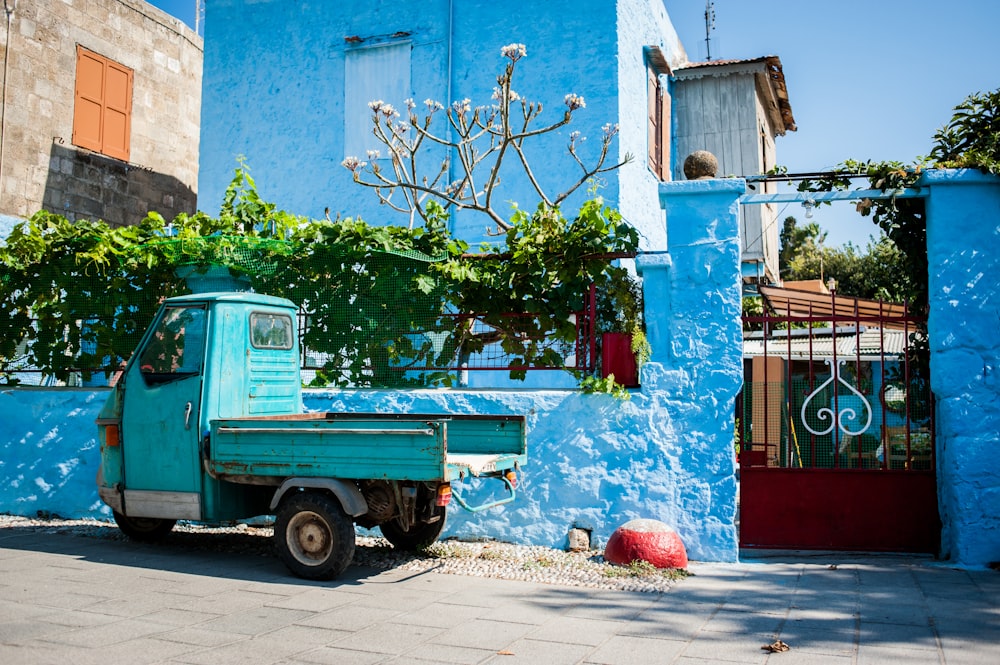 blue car parked beside red and white concrete building during daytime