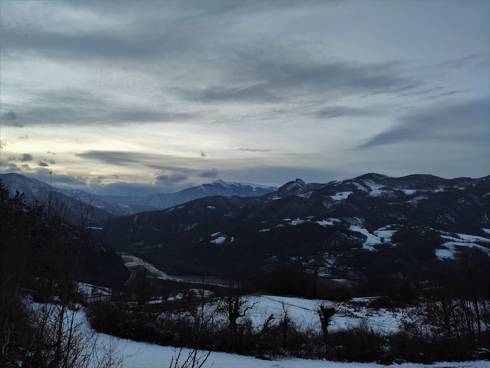 snow covered mountains under cloudy sky during daytime