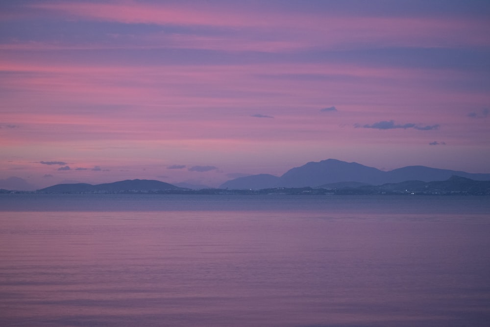 body of water near mountain during daytime