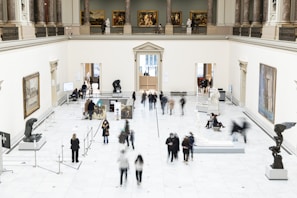 A bustling art gallery opening night with visitors admiring contemporary pieces