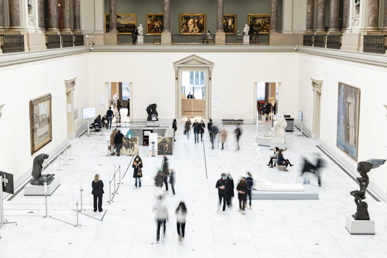 A vibrant gallery space filled with contemporary art pieces and visitors admiring the exhibits.