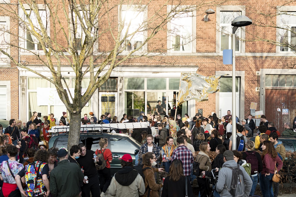 personnes debout près d’un bâtiment blanc pendant la journée