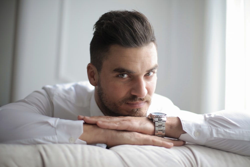 man in white dress shirt lying on bed