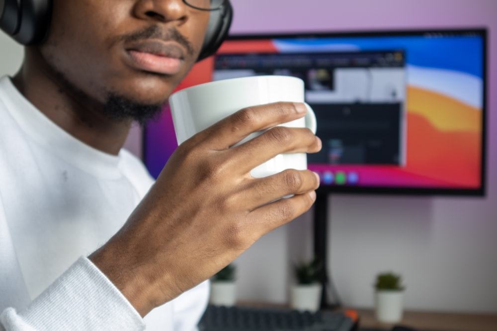 man in white dress shirt holding white cup