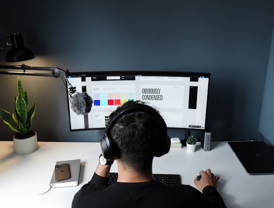 man in black shirt sitting in front of computer