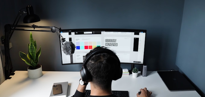 man in black shirt sitting in front of computer