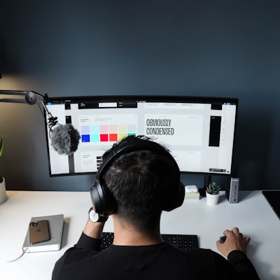 man in black shirt sitting in front of computer