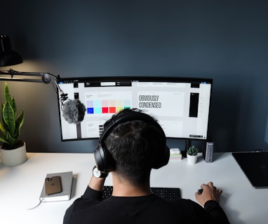 man in black shirt sitting in front of computer