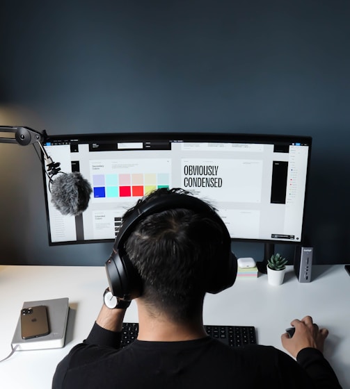 man in black shirt sitting in front of computer