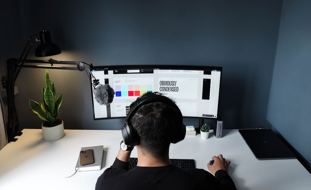 man in black shirt sitting in front of computer