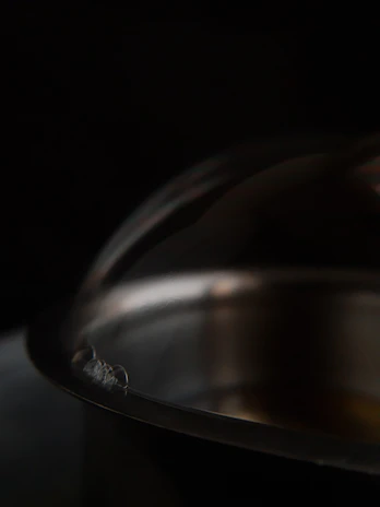 A close-up shot of a polished copper dinner plate catching the light.