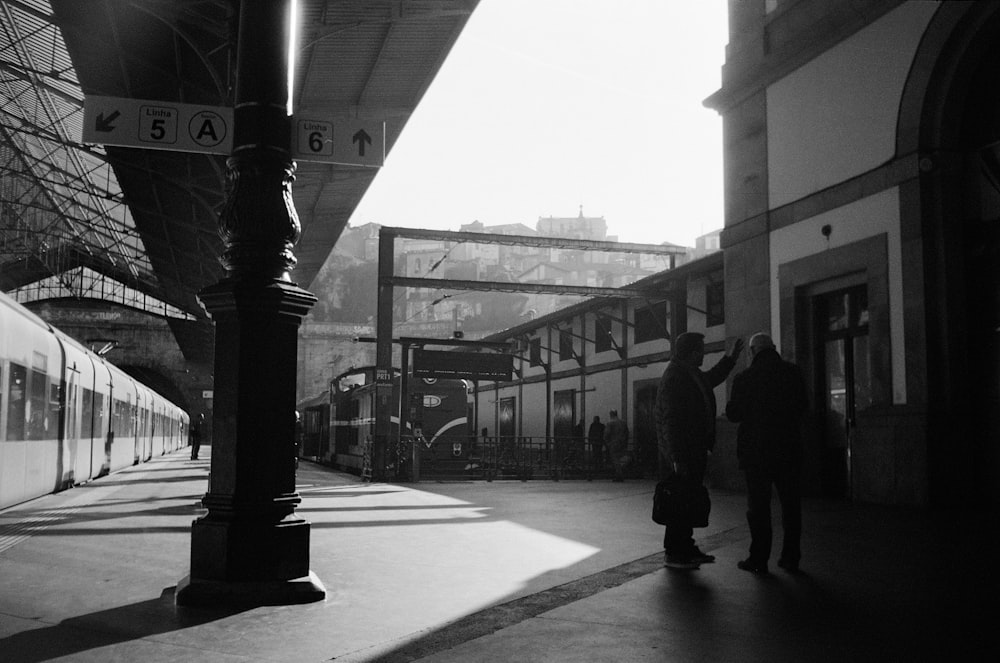 grayscale photo of people walking on sidewalk