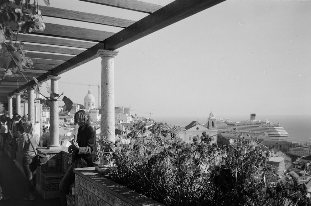 Foto in scala di grigi di uomo e donna seduti sulla panchina