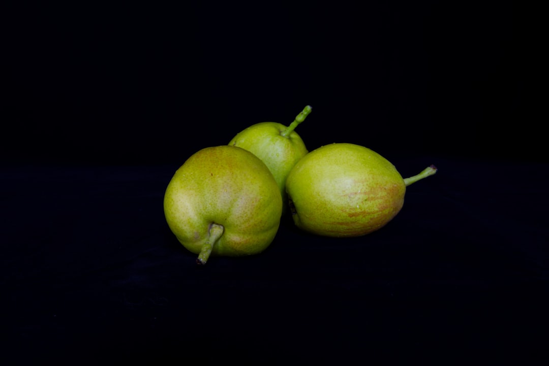 two green apples on black surface