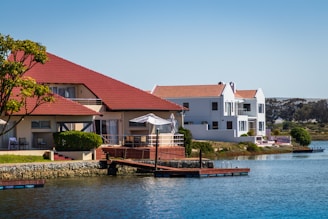 brown boat on body of water near houses during daytime