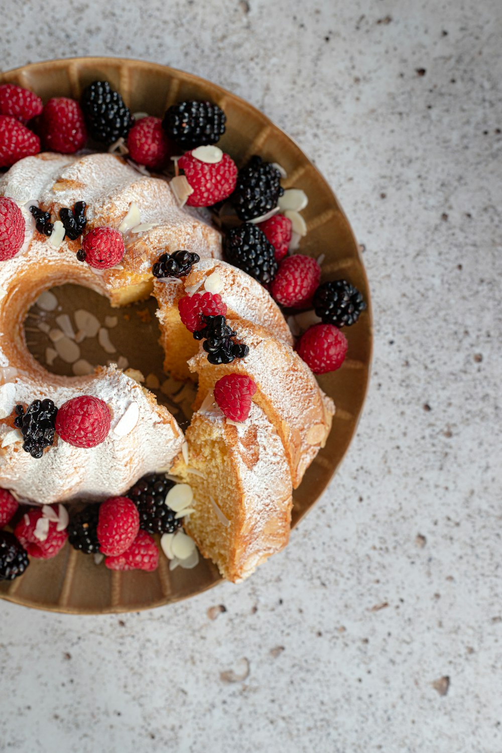 brown and white donut with strawberry and blueberry on top