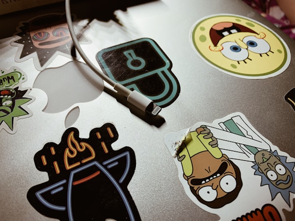 A vibrant collection of custom vinyl stickers arranged on a laptop cover.