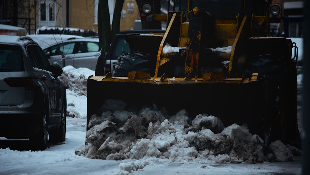 yellow heavy equipment on snow covered ground during daytime