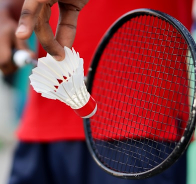 person holding red and black tennis racket