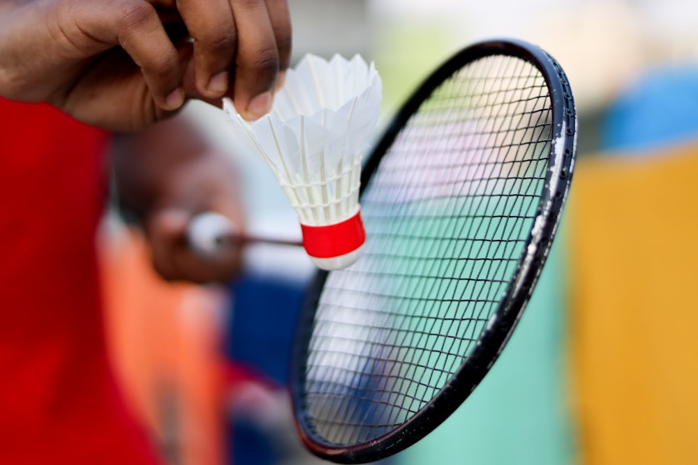 personne tenant une raquette de tennis noire et blanche