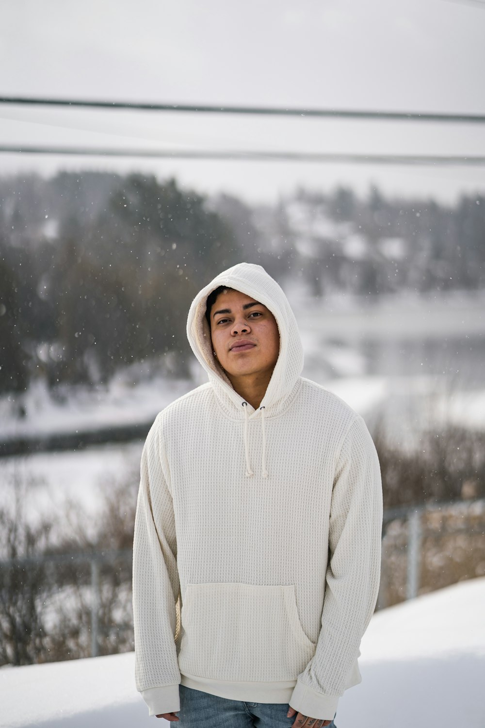 person in white hoodie standing on snow covered ground during daytime