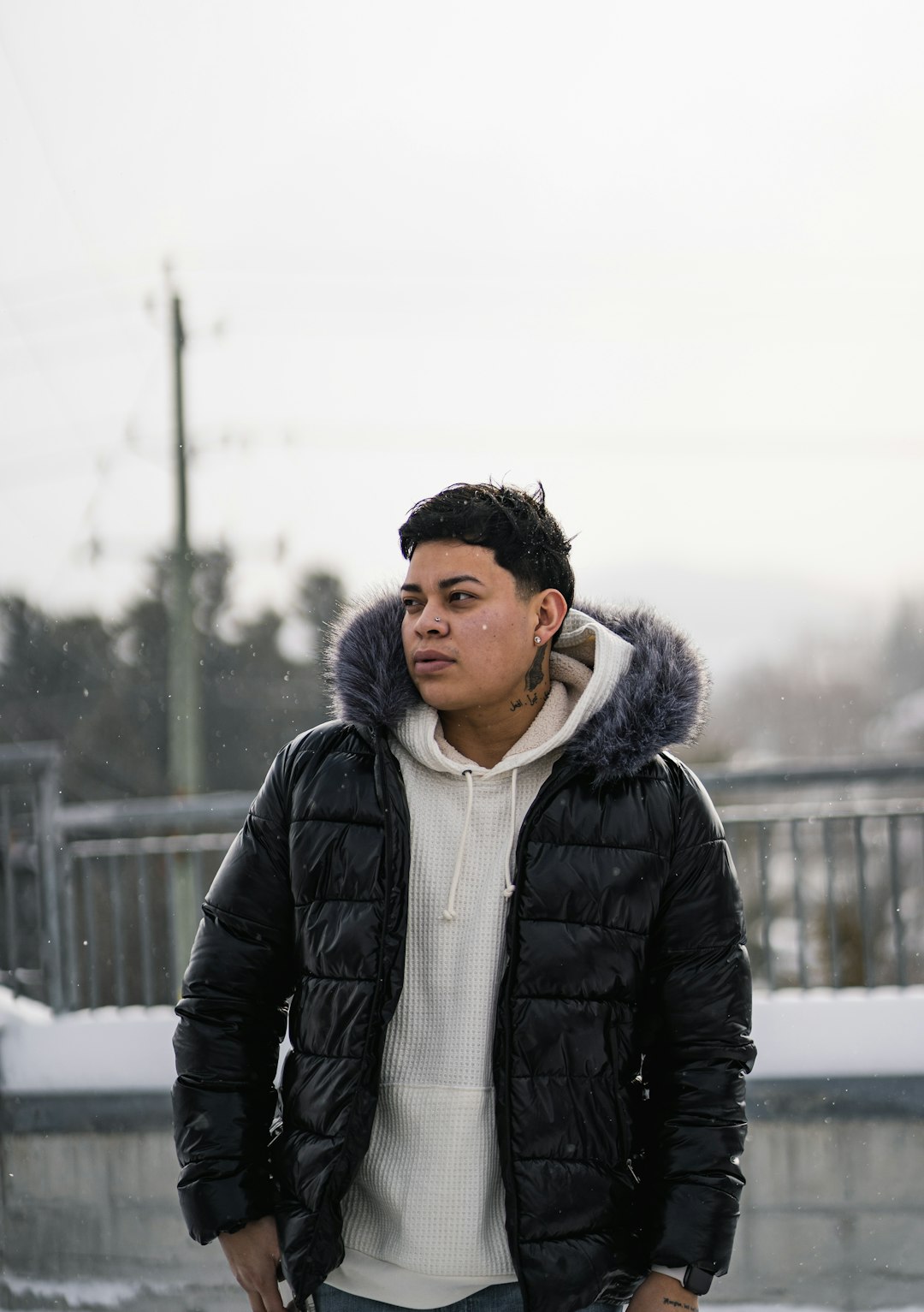 man in black jacket standing on snow covered ground during daytime