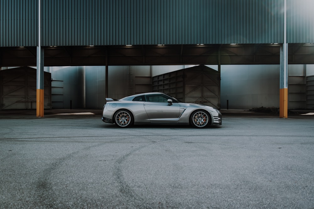 silver coupe parked near gray wall