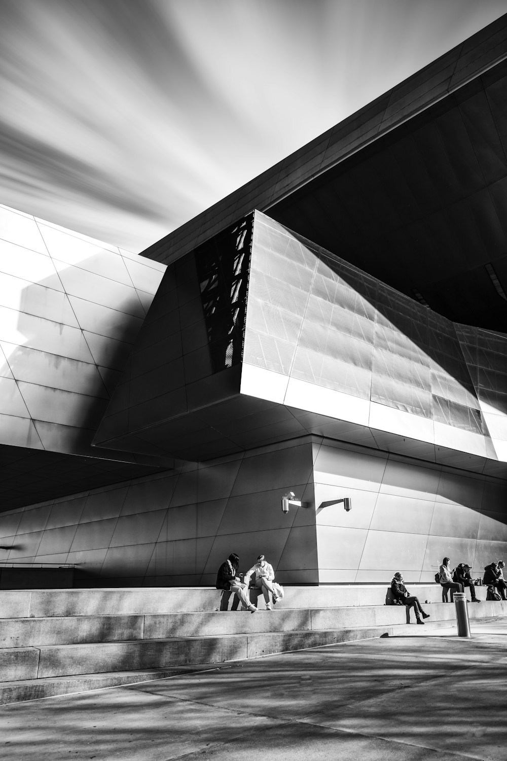 grayscale photo of people walking on white floor tiles