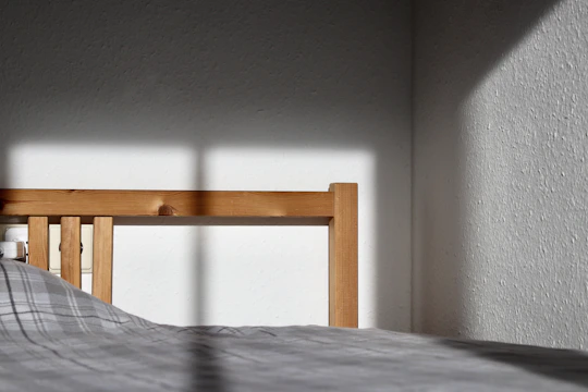 Close-up of a bed frame being inspected for bed bugs.