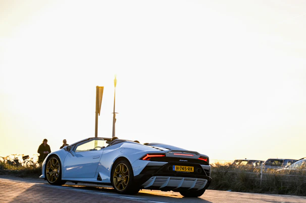 A blue convertible with the top down, gleaming under a bright afternoon sun.