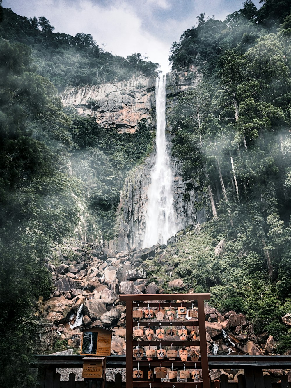 brown wooden bench near waterfalls during daytime